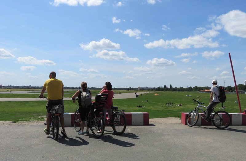 Radfahrende blicken von der Oderstraße auf das Tempelhofer Feld