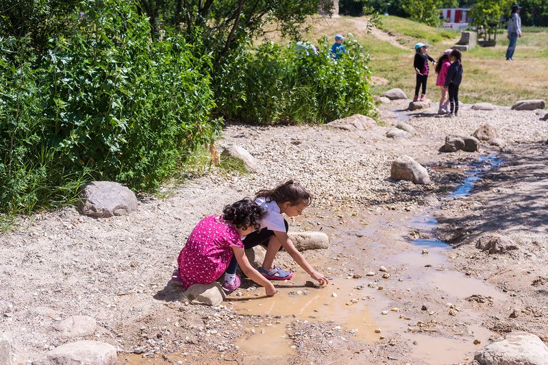 Kinder spielen im Wasserlauf des Naturerfahrungsraums