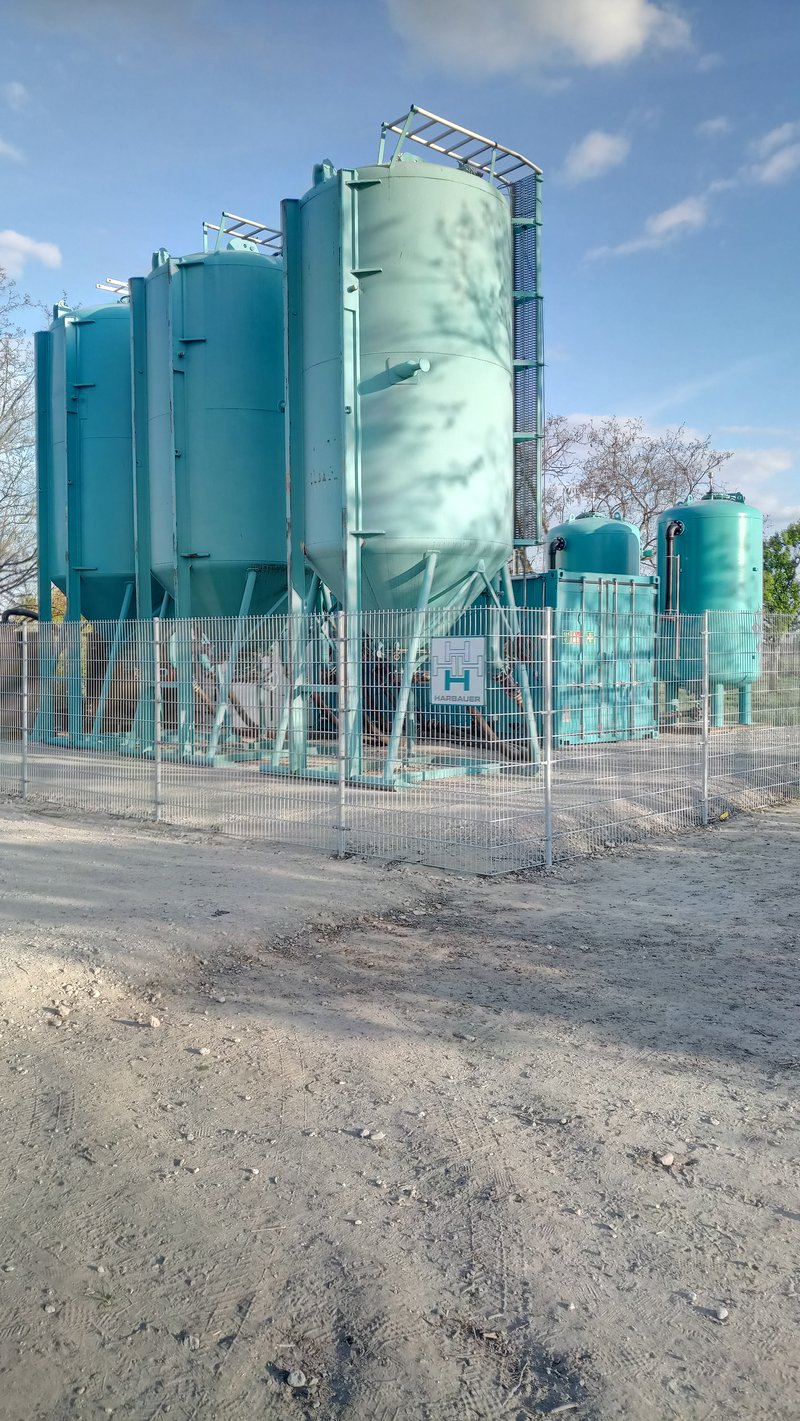 Riesige Tanks mit Bauzaun als Teil der Grundwassersanierung